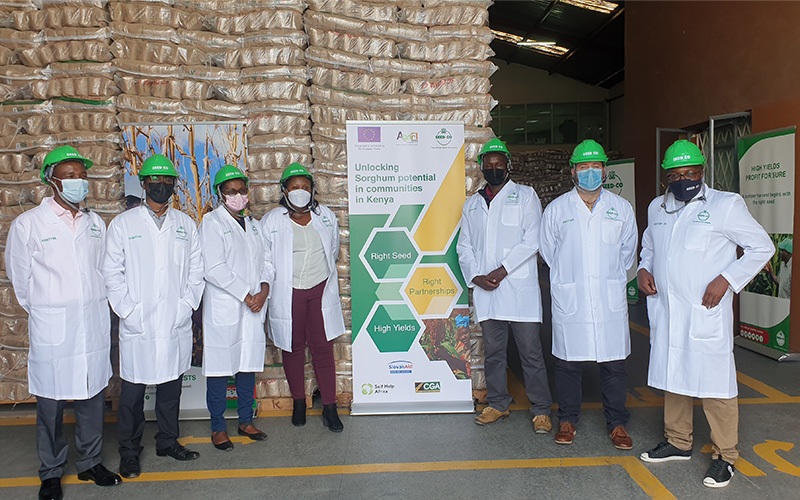 People in seed co lab coats in front of a banner
